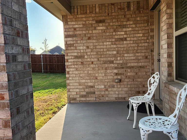 Covered patio with a brick exterior, concrete flooring, and a recessed ceiling light fixture