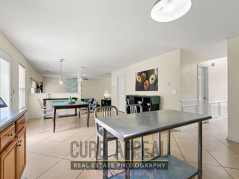 Open-concept dining area with tile floors, ample seating, and easy flow into the adjacent kitchen and living space.