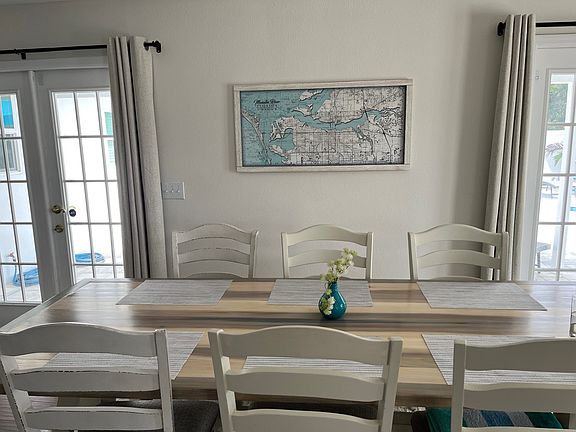Dining table for 8 with map of Bradenton area and AMI on the wall and view of the pool