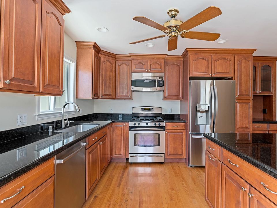 The kitchen is bright and spacious, with granite countertops, cherry cabinetry, and modern GE, LG, and Bosch appliances. (01)