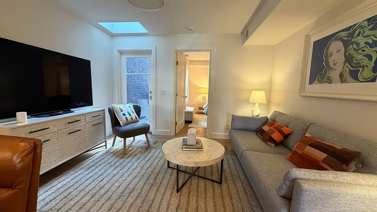 Large sunny living room with all new, comfy furnishings (shows skylight and door to private rear patio) - 134 Delmar St
