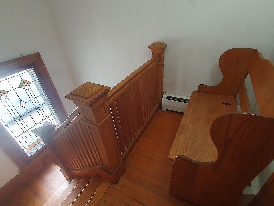 Stained glass landing between 1st and 2nd floor with bench.