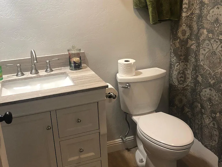 Bathroom off bedroom with new toilet, faucet and cabinet