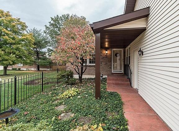 Stamped concrete walk-way with a covered porch overhang to the garage door.