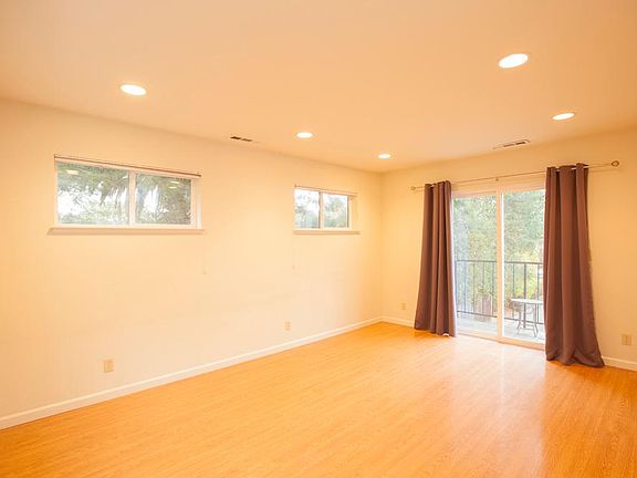 Well lit living room with balcony and courtyard view overlooking lovely neighborhood
