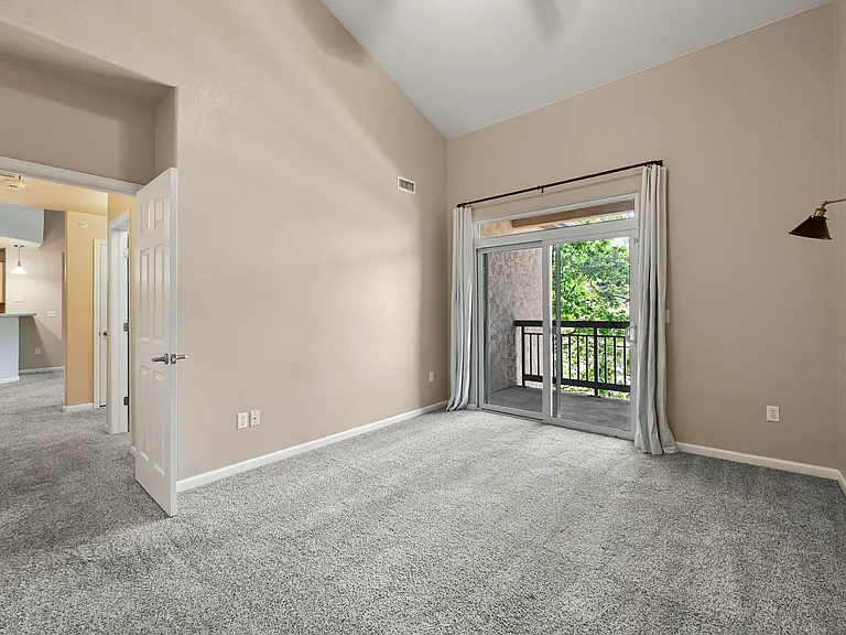 Spacious Primary Bedroom: Vaulted ceilings, private balcony (with storage), walk-in closet, en-suite bath adjoins.