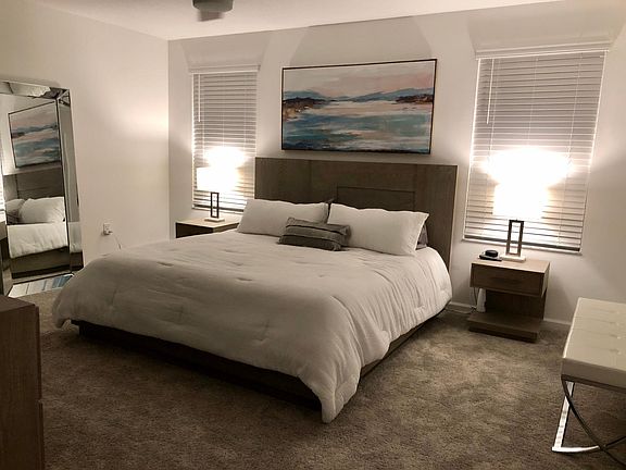 Master bedroom is spacious with king bed and 65 inch tv on wall