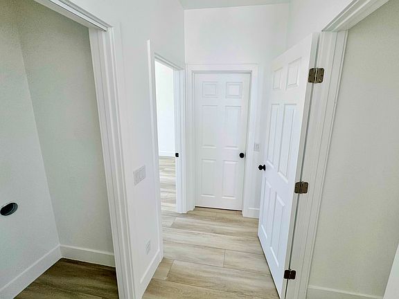 Laundry room on the left, storage closet on the right, bathroom at the end of the hallway between 2 bedrooms