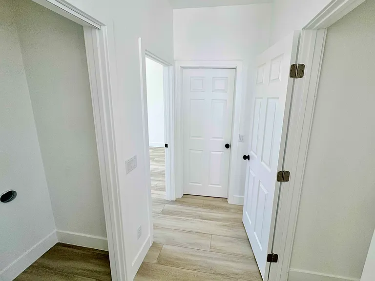 Laundry room on the left, storage closet on the right, bathroom at the end of the hallway between 2 bedrooms