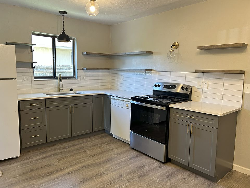Fully refinished kitchen that's adorable with floating shelves and gold/black accents.