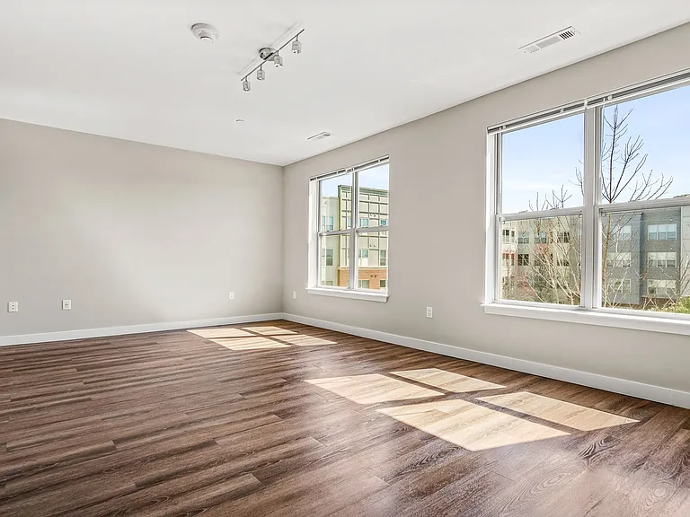 This bright and spacious living room features large windows that fill the space with abundant natural light