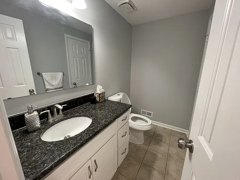 Downstairs half bath with granite countertops, real wood cabinets with soft close hinges/drawers, and floating mirror.