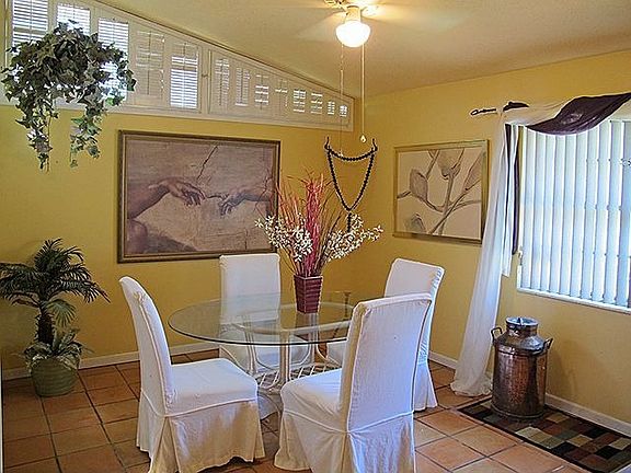Dining area with vaulted ceiling/window, and custom shutters.