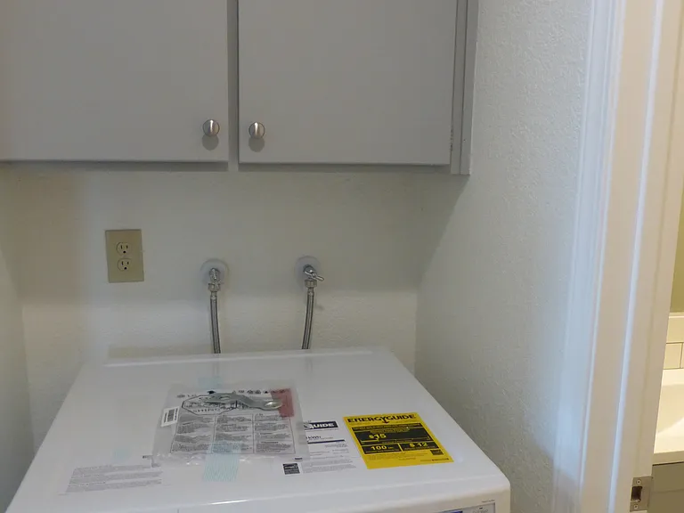 New front loading washing machine with cabinet storage.