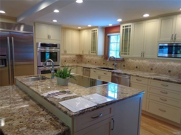 Stunning chef's kitchen comes fully equipped with top brand appliances. Convection oven and regular oven.Trash compactor, electric touch control cook-top with memory. Granite countertops.