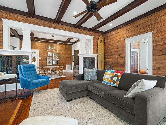 Living room looking into dining area. Original shiplap walls and coffered ceiling