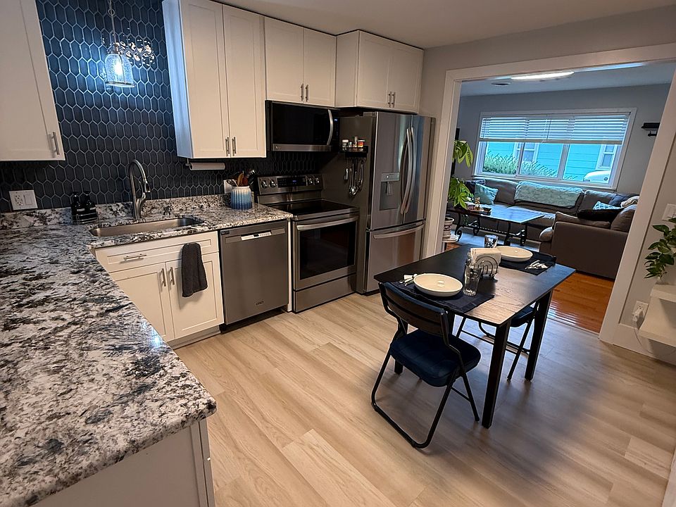 Kitchen: beautiful tile backsplash, stainless steel appliances, large sink, granite counters with back screen door out to backyard space