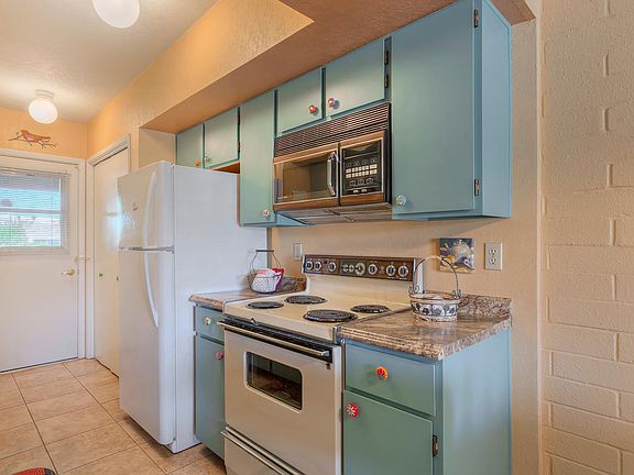 Newly refinished kitchen cabinets with whimsical hand painted knobs.
Microwave and electric stove.