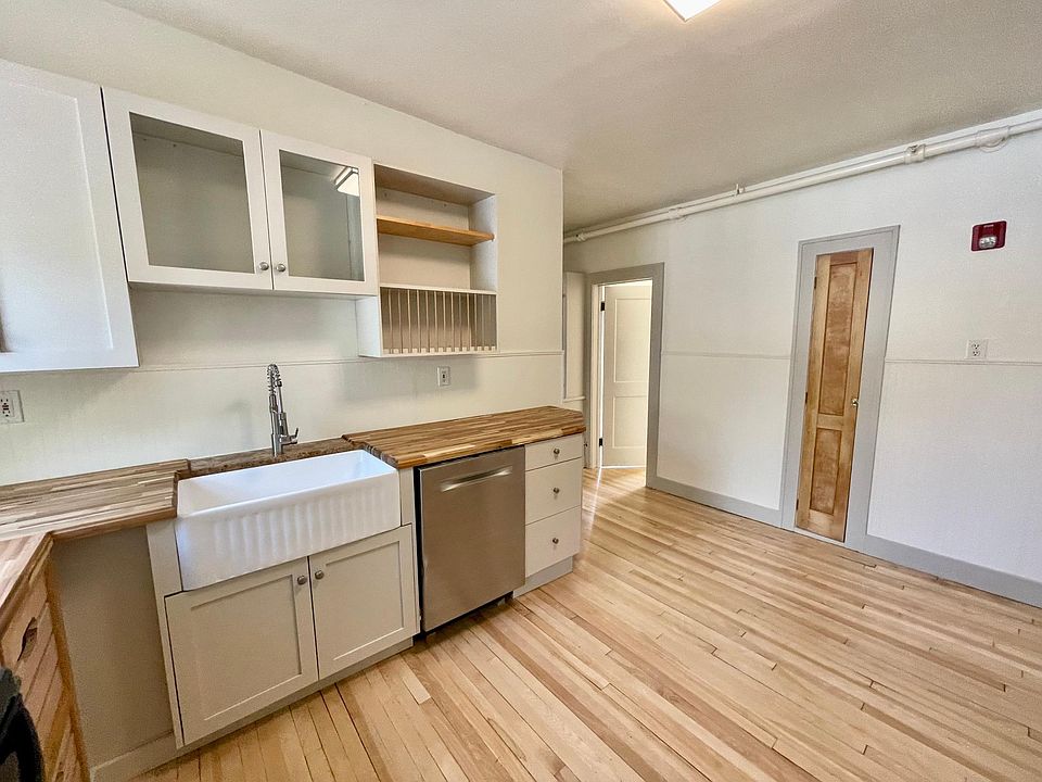 Large kitchen with Bosch stainless steel dishwasher, stunning farm sink, hardwood floors, solid wood cabinetry, and butcher block countertops