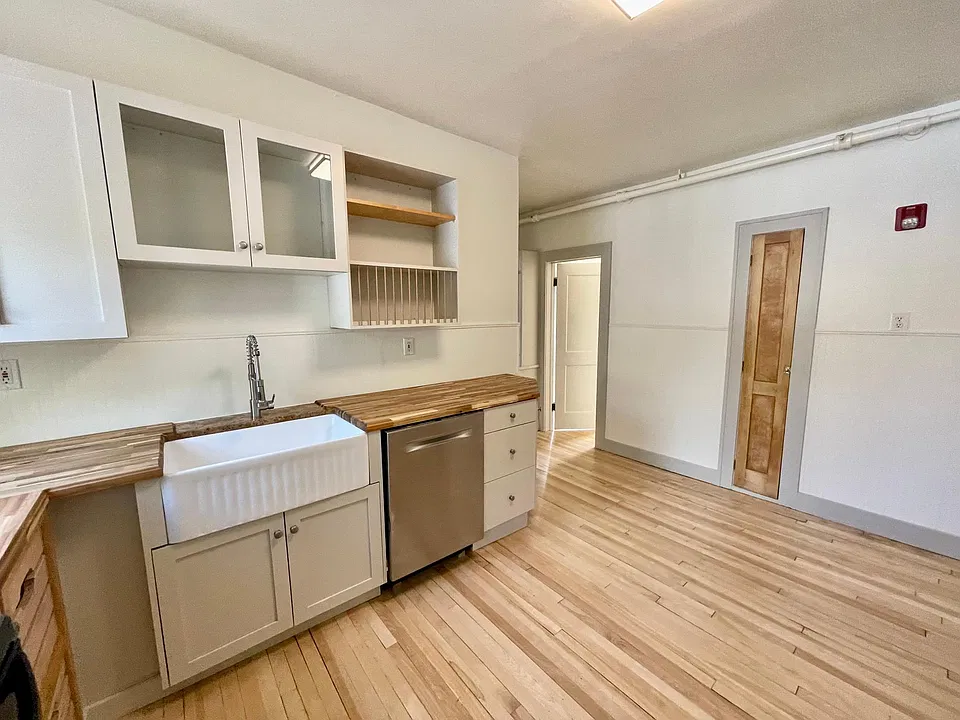 Large kitchen with Bosch stainless steel dishwasher, stunning farm sink, hardwood floors, solid wood cabinetry, and butcher block countertops