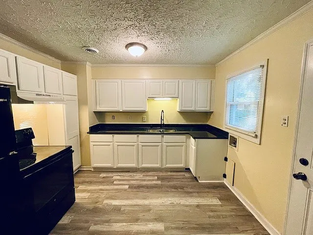 _ Freshly renovated cozy kitchen alert! Featuring sleek black appliances, stunning granite countertops, and warm laminate wood flooring_perfect for whipping up meals with style! __ #KitchenGoals #HomeRenovation #CozyLiving