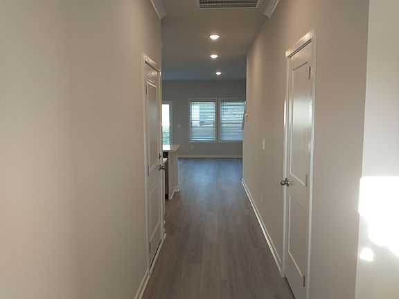 Hallway from front door entrance with access to garage on the left and a half bath on the right.