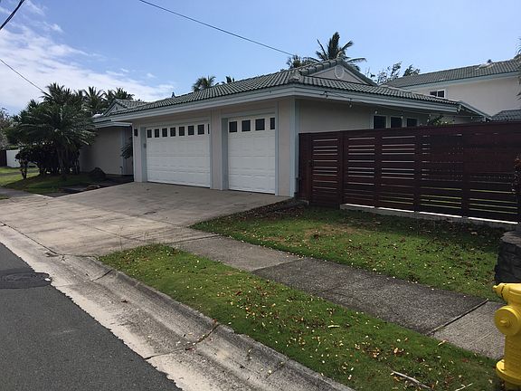 Curbside view of property showing side yard and rental entry gate.