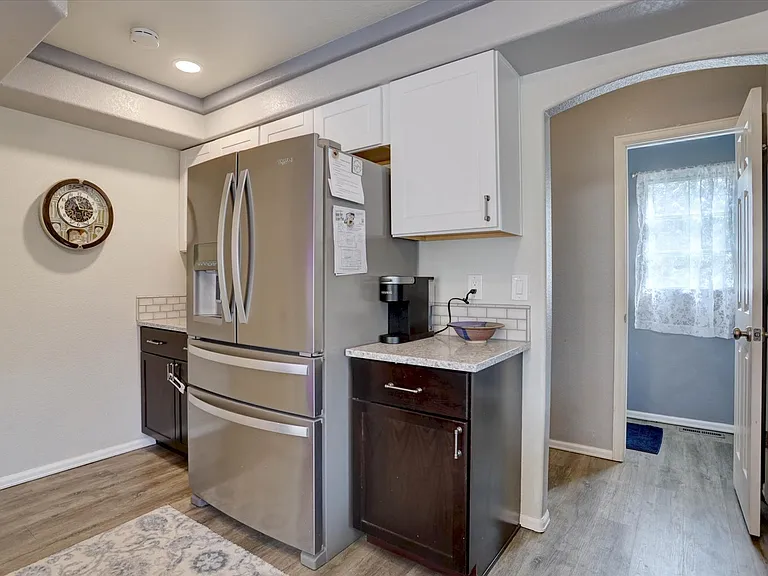 Kitchen with door to main half bath and hallway to garage