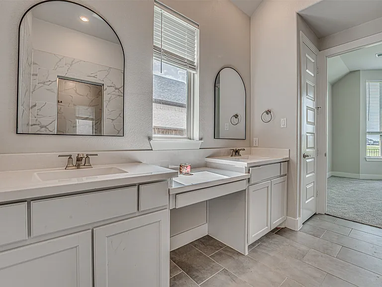 Dual vanities with white countertops and undermount sinks