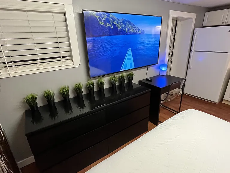 Queen bed, dual night stands with lamps, dresser, desk and chair, 65in Smart TV, full kitchen, bath.