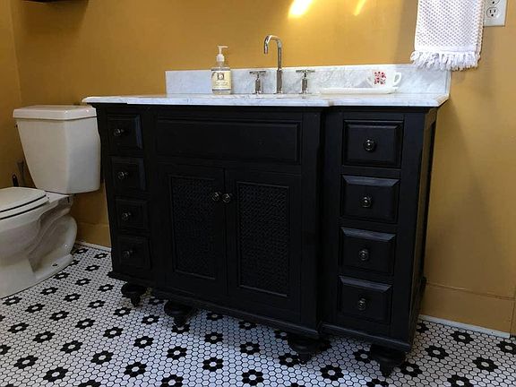 Large storage vanity and flower patterned hex tiles in the bathroom