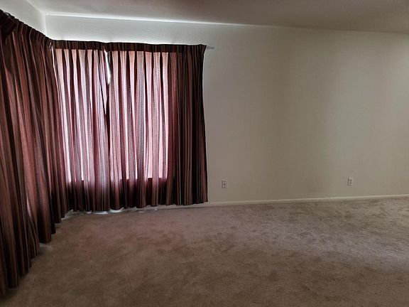 Spacious living room with large front windows for plenty of light. Dining area adjacent to living room