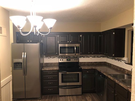 Remodeled kitchen with tiled backsplash and stainless steel appliances