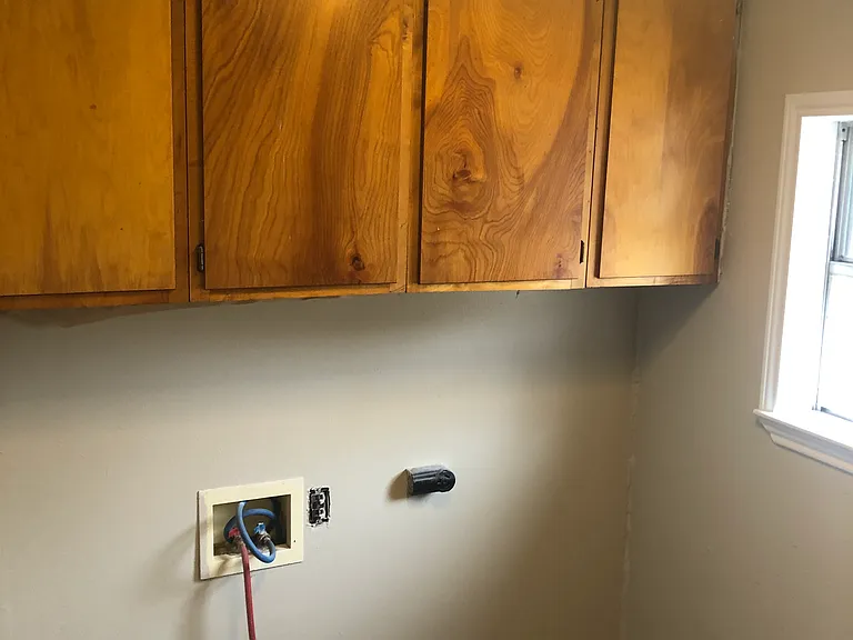 Separate laundry room with hookups and ample cabinet space.