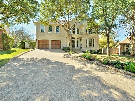 Wood stained garage doors, wood/wrought iron front door and freshly mulched landscaping add to the curb appeal of this home