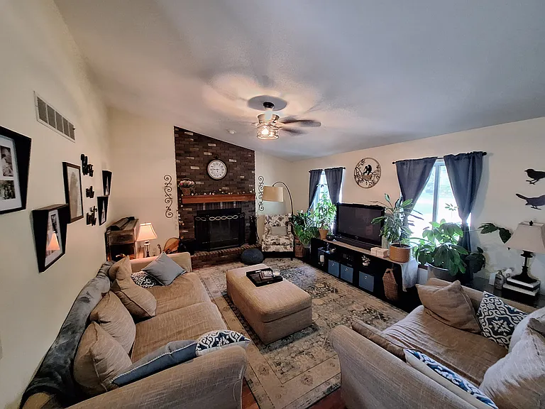 Wood burning fireplace and ceiling fan in the living room