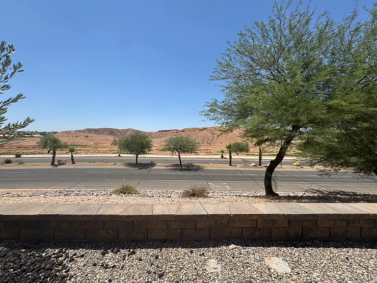 Scenic backyard view overlooking the golf course, pond, and surrounding hills to the right.