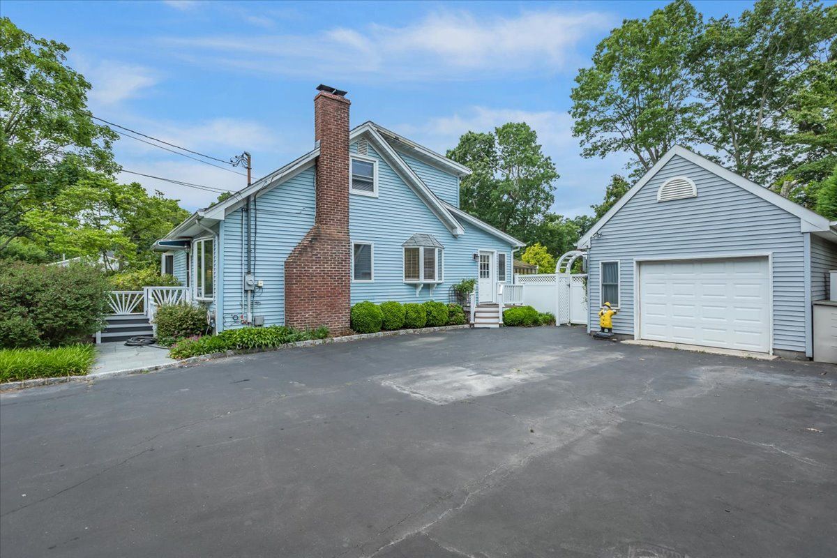  Side of Property with Detached One-Car Garage and Ample Large Driveway / Parking Lot.