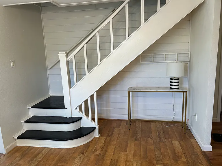 Staircase two upstairs and desk/workspace below stairs