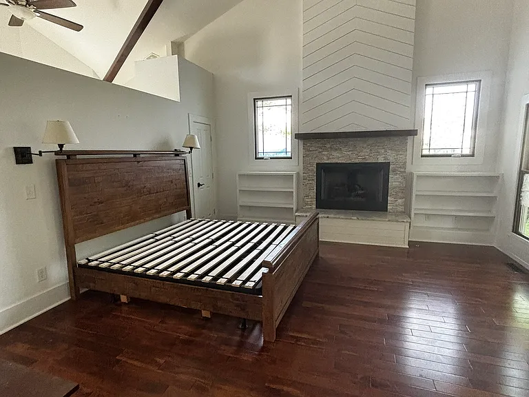Master bedroom with king bed (for scale). Vaulted ceilings with exposed beams. Built-in book shelves, linen closet and gas-burning fireplace.