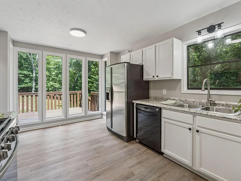Other side of kitchen with large windows overlooking back deck.