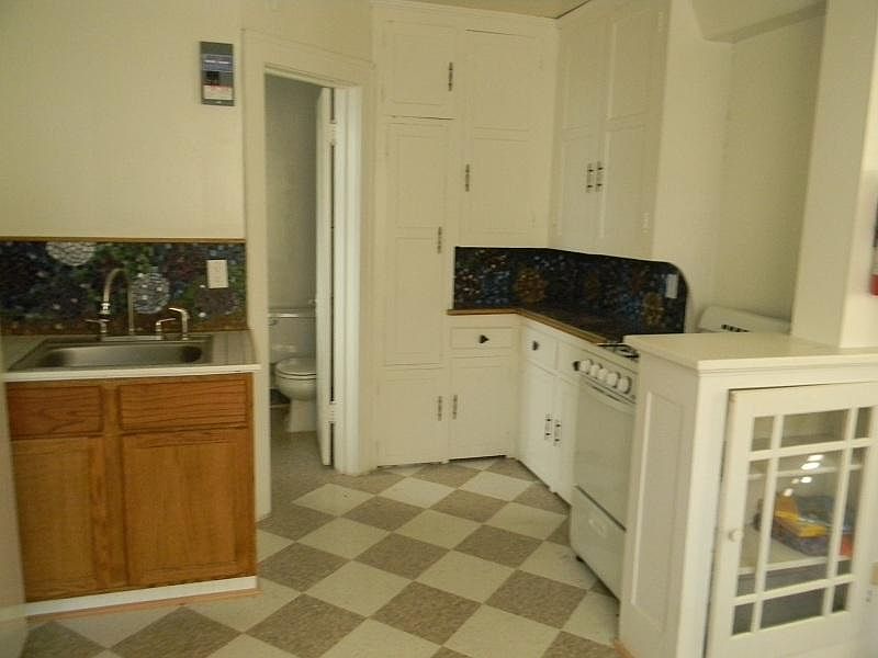 Historical built-in cabinets and arty mosaic walls in the kitchen