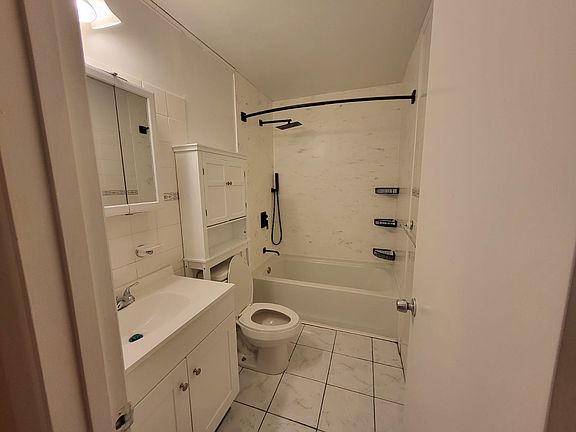 Step into our beautifully remodeled guest bathroom, featuring a gorgeous new shower/bath with a refreshing rain shower head. The stylish new tile flooring complements the space perfectly, and the addition of over-the-toilet storage maximizes functionality