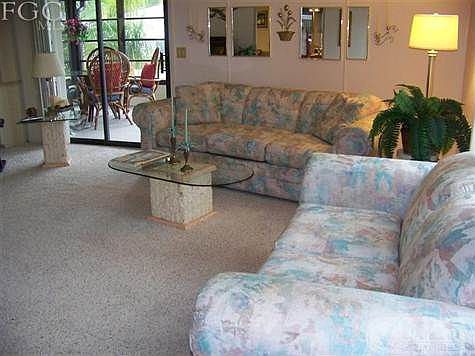 One side of this very large great room with sliders to lanai in the background.