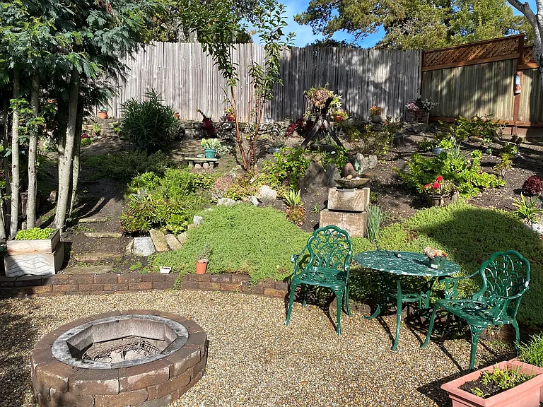Fenced and secluded backyard with firepit and fountain