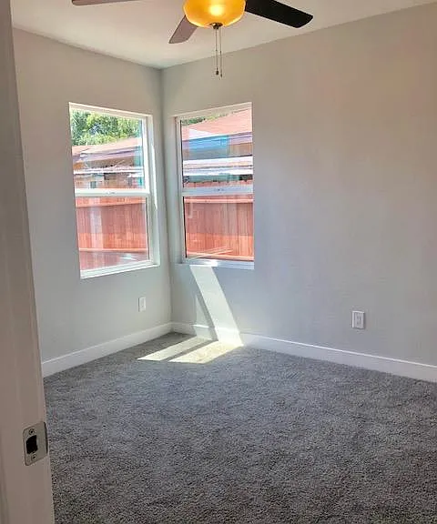 Bedroom 1 with new carpet, new windows, new paint and new ceiling fan