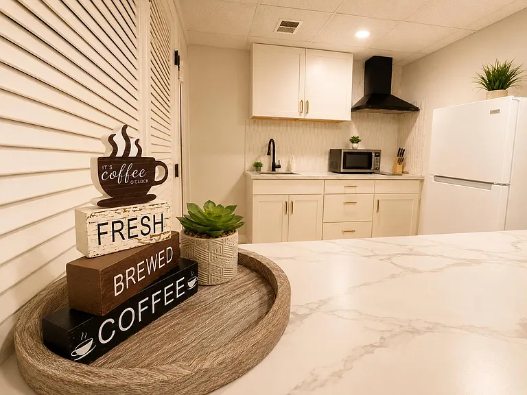 Updated kitchen with quartz-look counters, ample cabinetry, and a full appliance set including refrigerator and microwave.