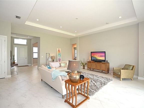 Family room with tray ceiling, downlights and tile flooring for easy care.