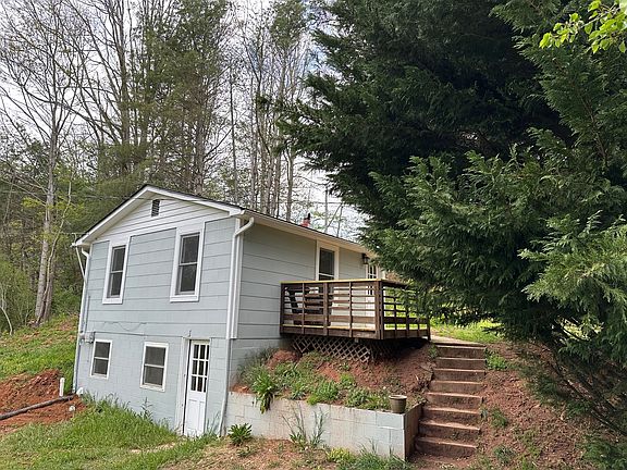 The cottage from the corner angle, both floors and the deck, plus stairs up to the upper front door.