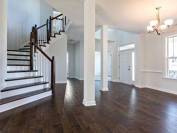 Solid oak stair treads with painted white risers enhance the beauty of this elegant and dramatic staircase!